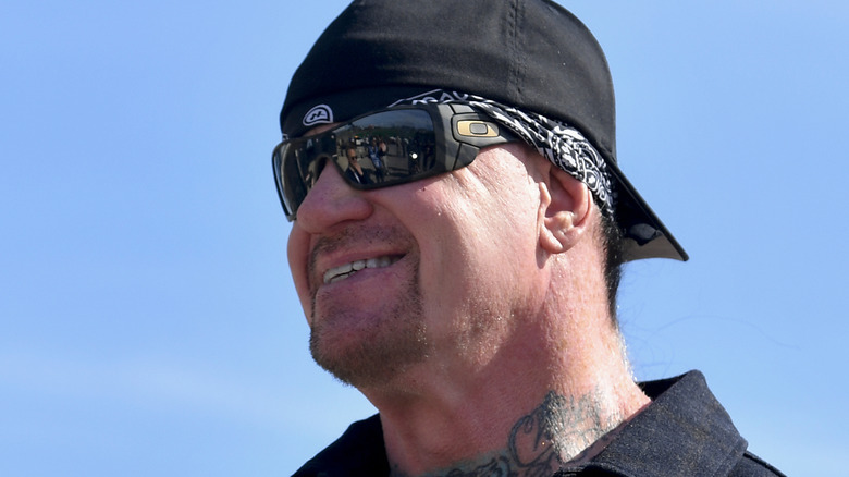 the undertaker wearing a backwards cap