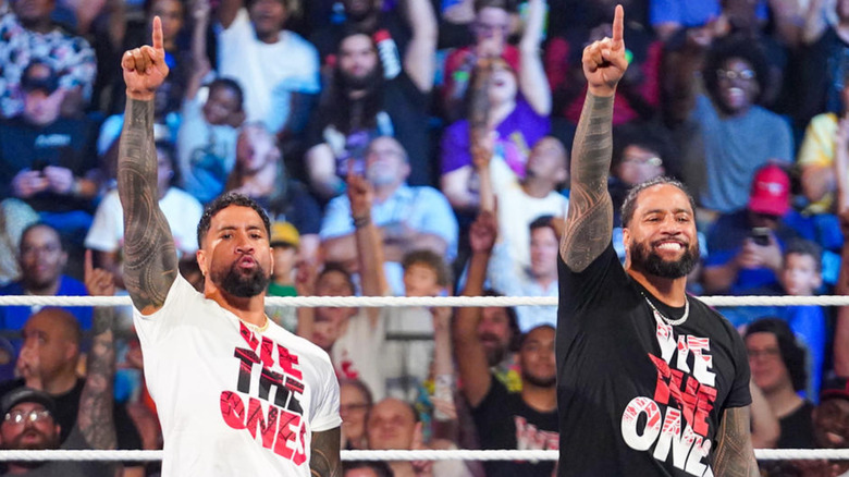 The Usos each raising one finger in the air