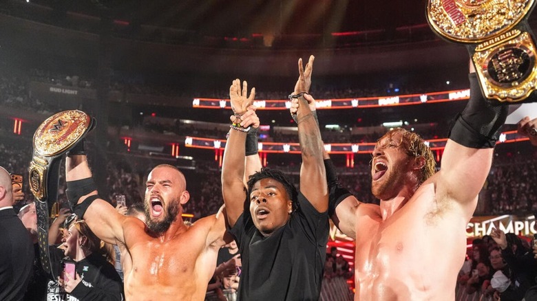 Logan Paul and Austin Theory hold up the arms of streamer IShowSpeed after their victory to win the WWE Tag Team Championships on 