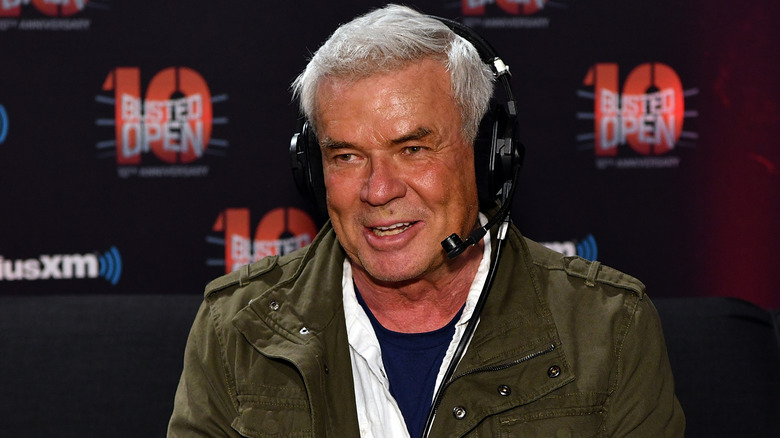 Eric Bischoff smiling and wearing a headset with a green jacket on