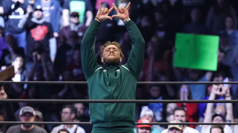 Will Ospreay raises his arms and makes W sign with fingers