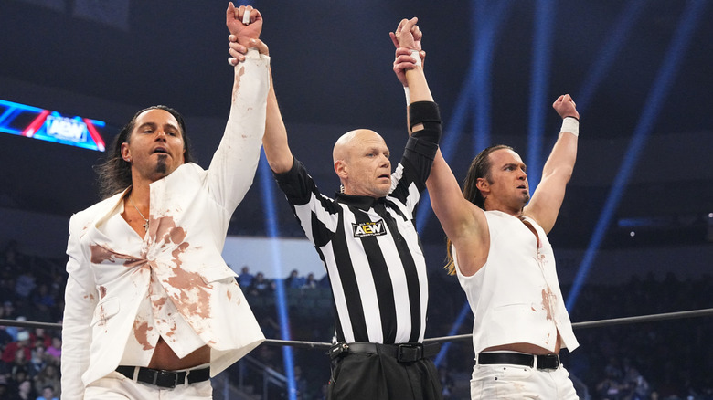 The Young Bucks with arms raised
