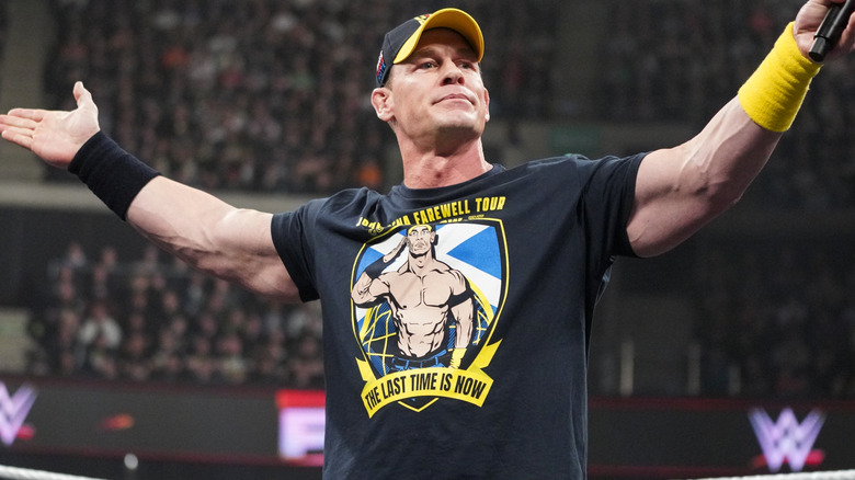 John Cena is outstretching his arms.