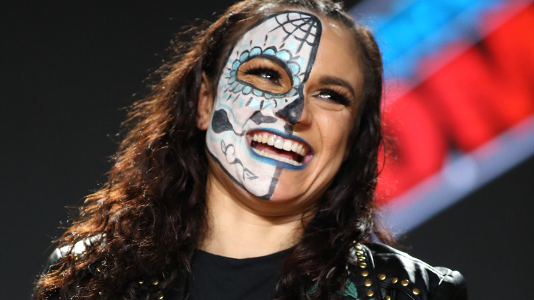 Thunder Rosa smiling at a panel with her face paint on
