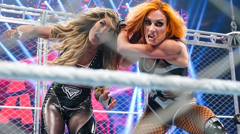 Becky Lynch has Trish Stratus by the hair inside steel cage