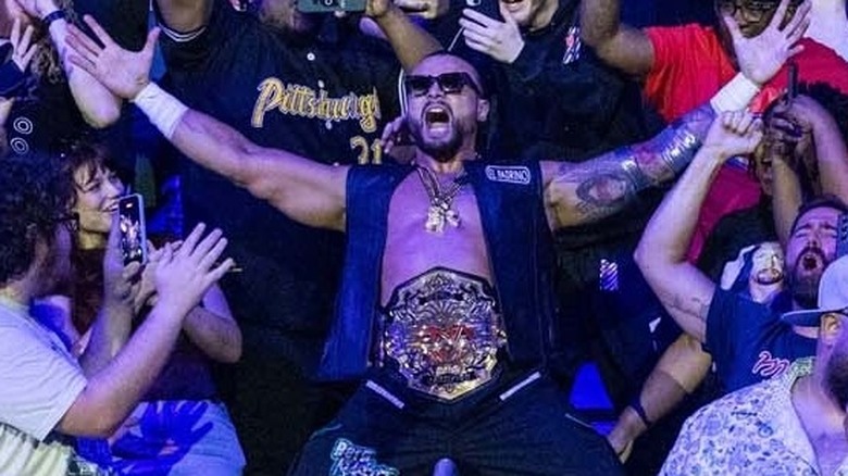 Mike Santana stands among the fans with the TNA World Championship wrapped around his waist