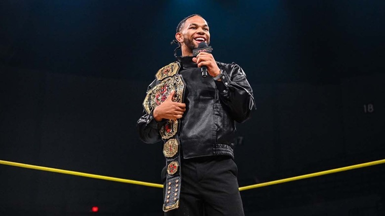 Leon Slater with TNA World Heavyweight Championship on his shoulder
