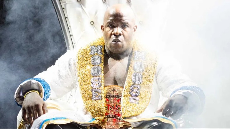 Moose sits on a throne as he's being led out to the ring