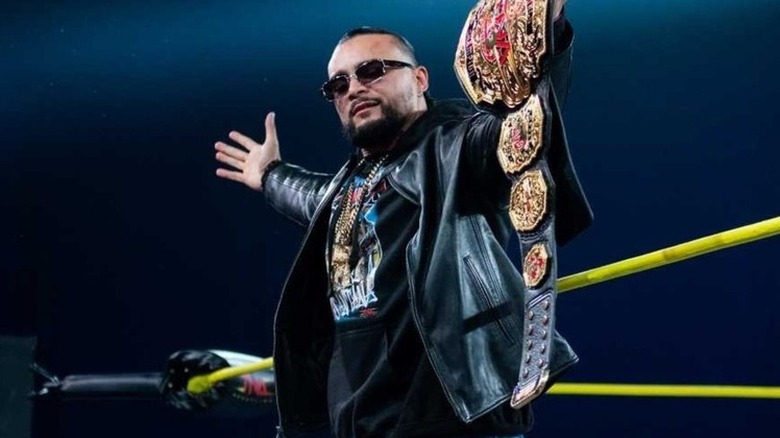 Mike Santana poses with the TNA World Championship up on the apron