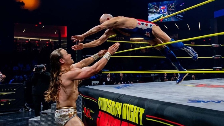 Action Mike Jackson diving between the ropes onto Mr. Elegance