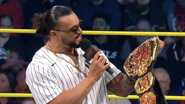 Santana in the ring looking at his TNA World Championship belt