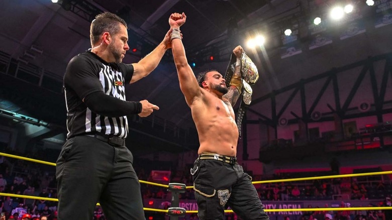 Mike Santana stands tall with his hand raised as the TNA World Champion
