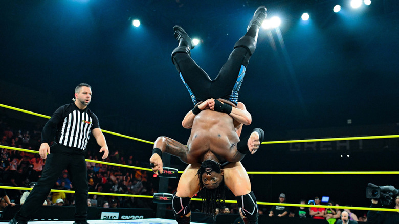 Cedric Alexander held upside down in the ring