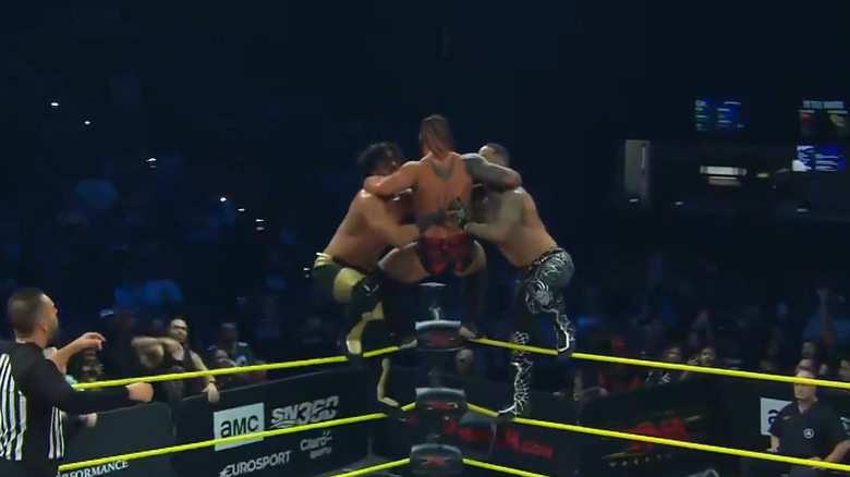 Mustafa Ali, Jason Hotch, and Trey Miguel on the top rope
