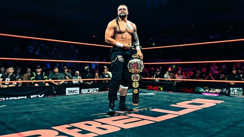 Mike Santana holding the title