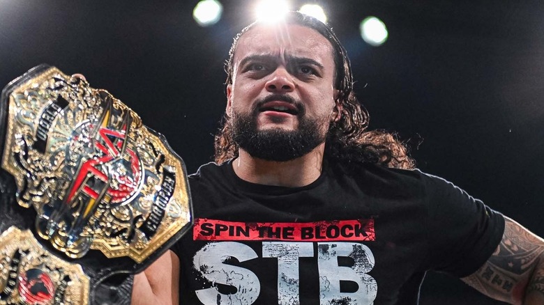 TNA World Champion Mike Santana gestures with the belt over the ropes while looking an his opponent during an episode of 