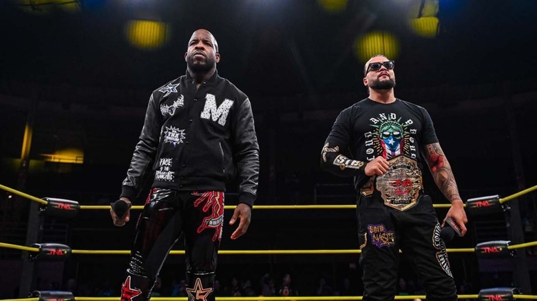 Moose stands alongside TNA Champion Mike Santana in the ring during a segment on an episode of 