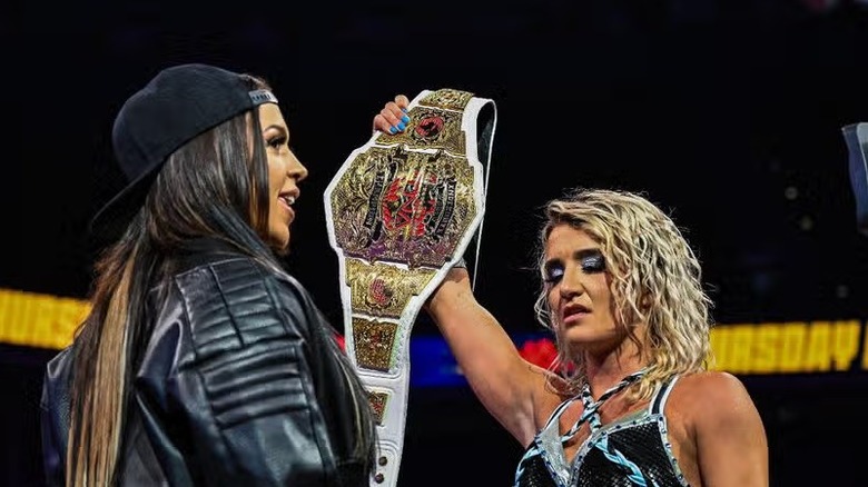 TNA Knockouts World Champion Xia Brookside holds her title high in front of Elayna Black's face