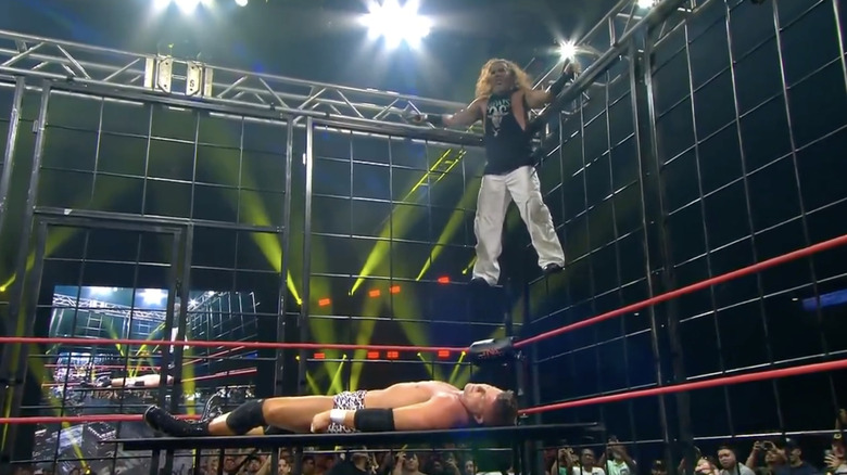 Matt standing on the side of the cage as Ryan is laying on the table