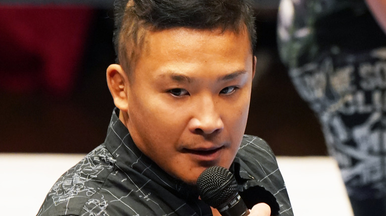 KUSHIDA speaking into a microphone
