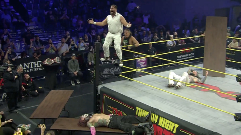 All four men around the ringside area with tables everywhere