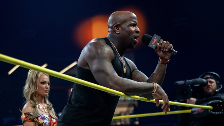 Moose talking in the ring as Alisha stands behind him
