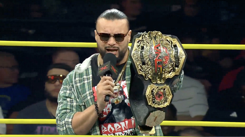 Santana in the ring holding up his TNA World Championship belt