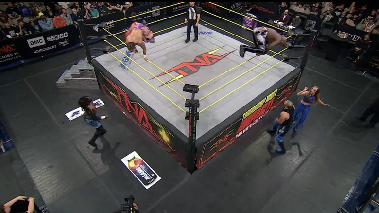 Slater and Moose flying out of the ring to level Alexander and Eddie on the outside