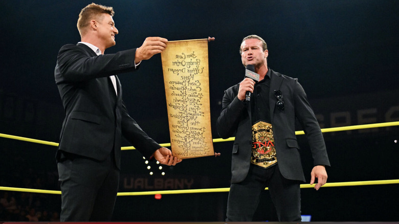 Nic reading off a scroll that Ryan is holding up