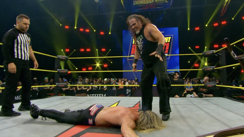 Matt standing over Nic inside the ring