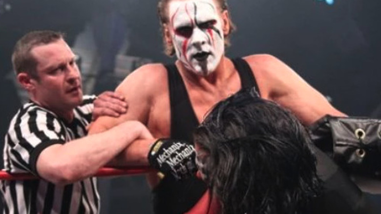 Sting stands over Jeff Hardy while the referee pulls on his arm at TNA Victory Road 2011