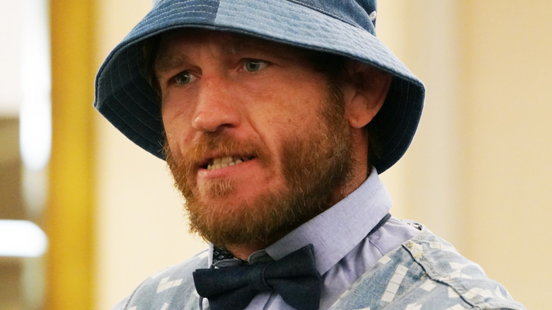 Tom Lawlor in a bucket hat wearing a bow tie at the G1 Climax Press Conference