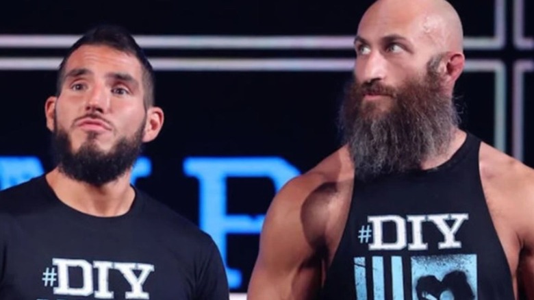 Tommaso Ciampa and Johnny Gargano stand on the stage before heading to the ring in WWE.