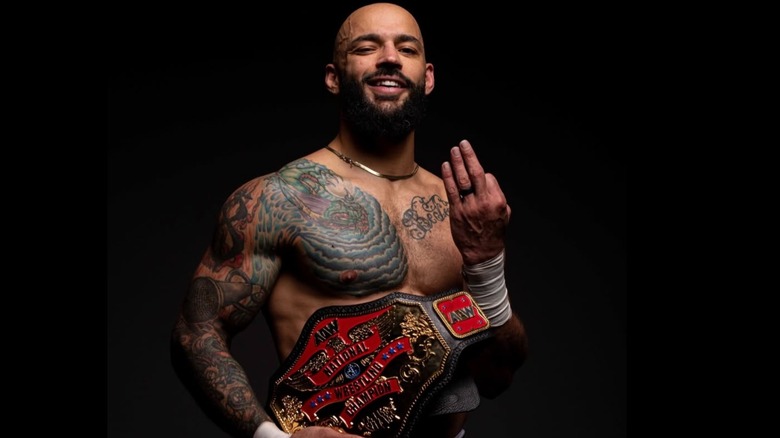 Ricochet poses with his newly won AEW National Championship