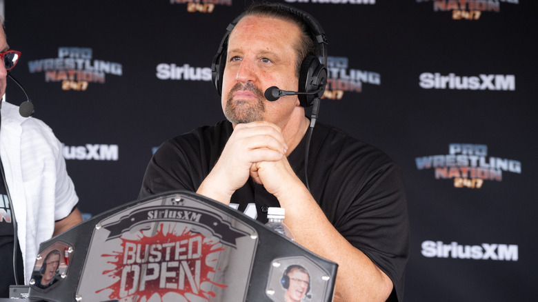 Tommy Dreamer sitting behind a Busted Open championship belt