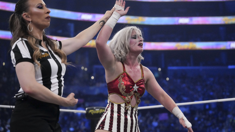 Referee Aubrey Edwards holds up Toni Storm's arm in victory following her match against Marina Shafir at AEW Revolution.