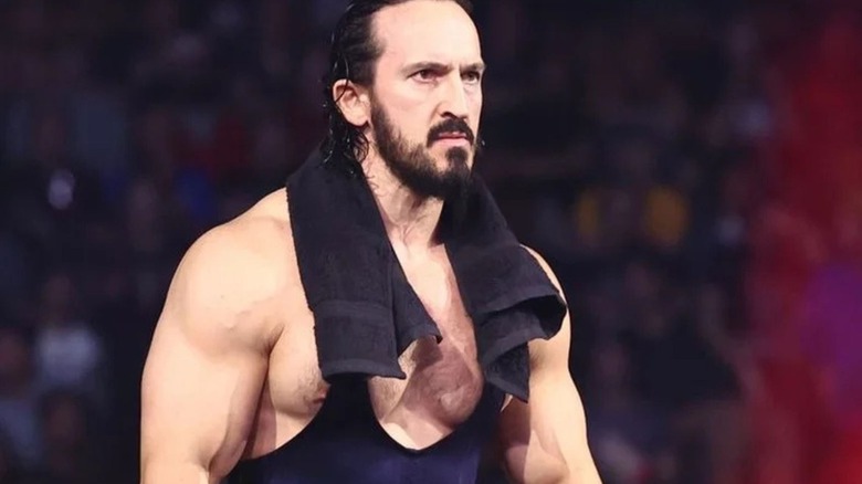 AEW star Pac heads to the ring, towel around his neck, to assist during a match on an episode of AEW programming.