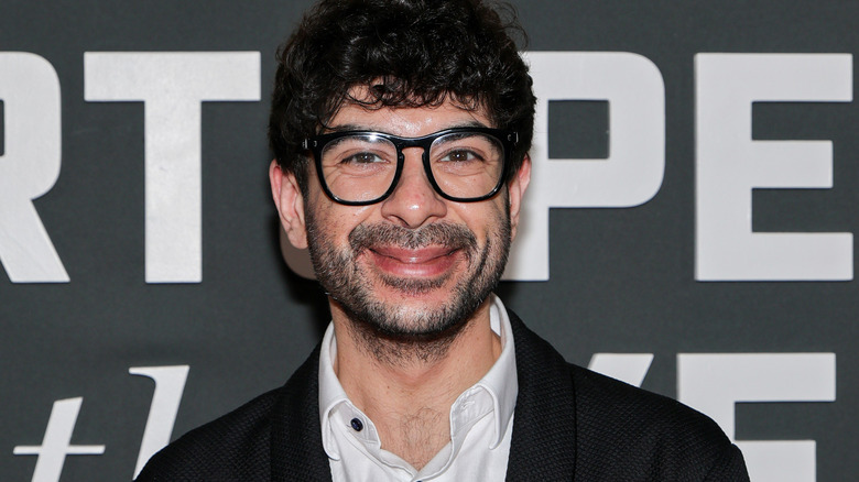 A bespectacled Tony Khan smiles at a Sports Illustrated event.