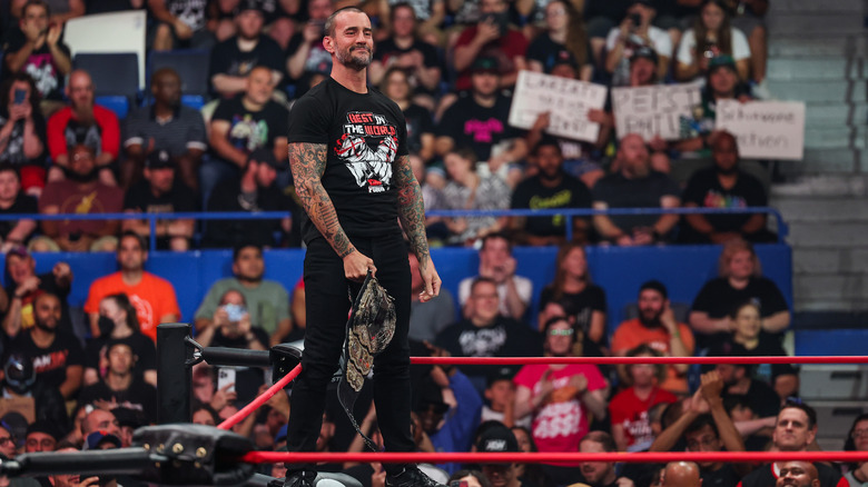 CM Punk stands on the middle rope and smirks