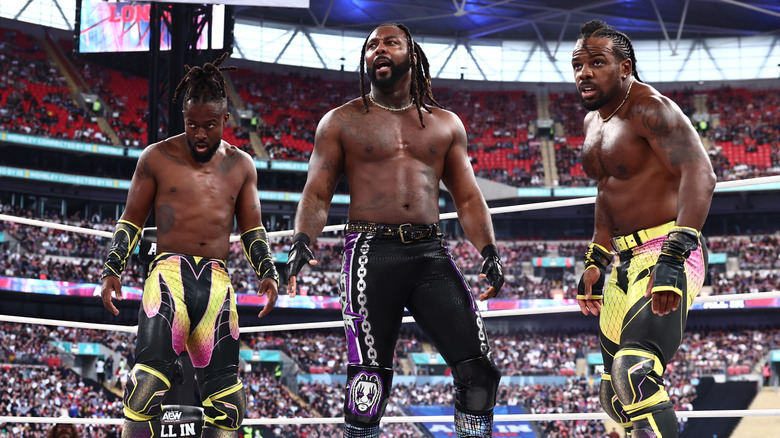 Kofi, Swerve Strickland, and Austin Creed stare down opponents in the ring during the AEW World Trios Championship roulette battle royal at AEW All In London 2026.