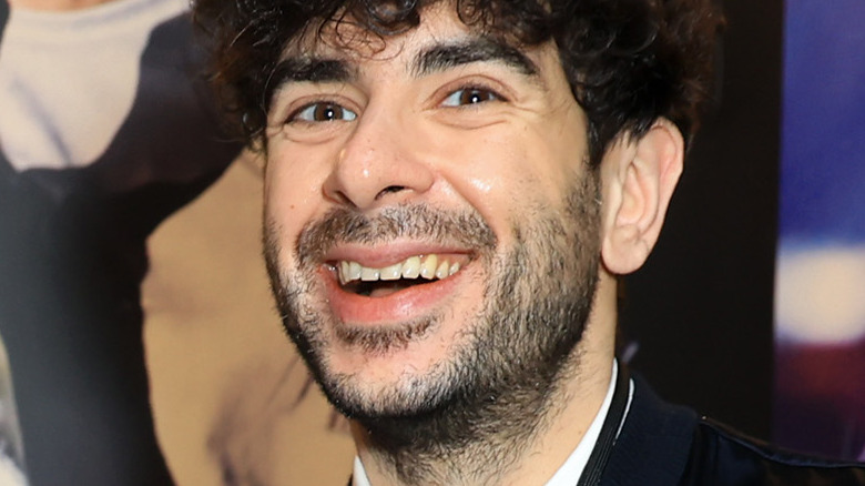 Tony Khan smiling in front of photo backdrop