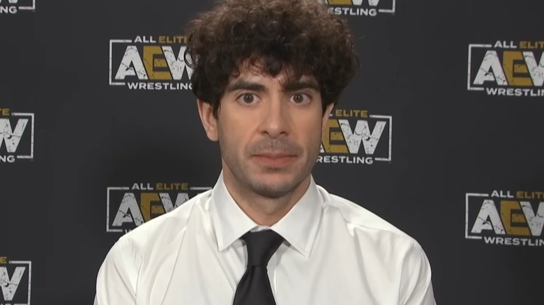 Tony Khan standing in front of AEW backdrop