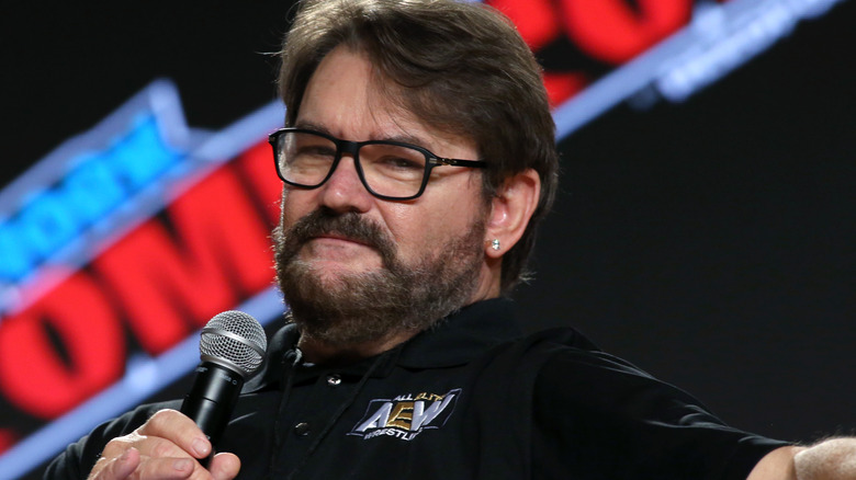Tony Schiavone and his earring look into the crowd, judging them