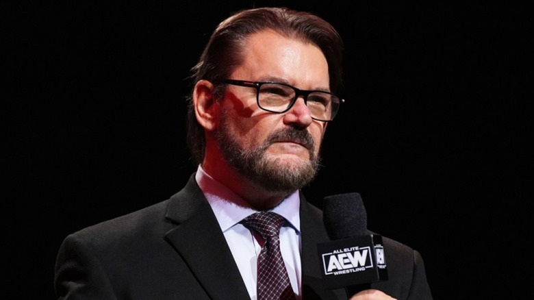 Tony Schiavone speaking on a mic during a television segment on AEW.