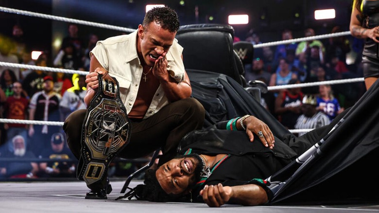 Ricky Saints standing over Trick Williams with the NXT Championship in-hand