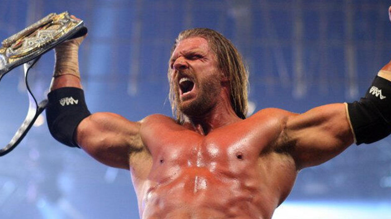 Triple H roars as he holds the WWE world title.
