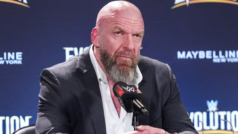 Triple H is sitting in front of a microphone
