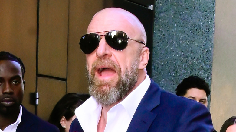 Triple H shielding his eyes from the photographers