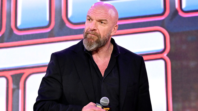 Paul Levesque wearing a black shirt and jacket