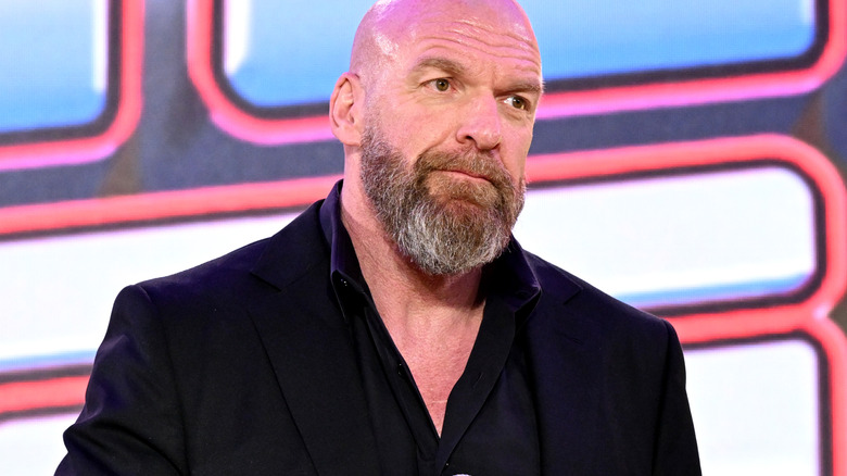 Paul "Triple H" Levesque holds a Fanatics microphone during a stage for SummerSlam.